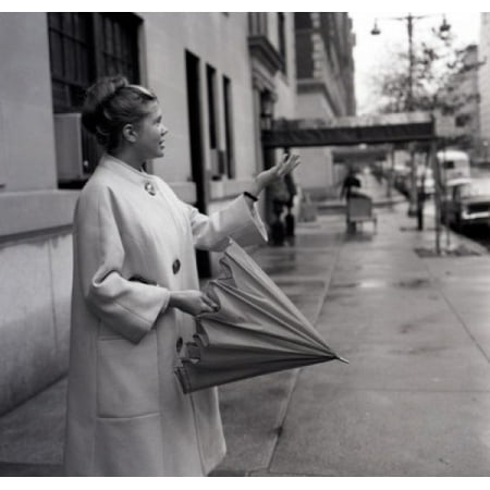 Young woman with folded umbrella checking if raining Stretched Canvas - (24 x 36)
