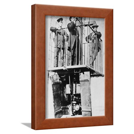 Men atop Exhibition's Electric Elevator Framed Print Wall Art