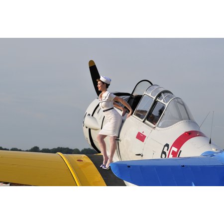 1940s style pin-up girl sitting on the wing of a vintage T-6 Texan aircraft Stretched Canvas - Christian KiefferStocktrek Images (18 x 12)
