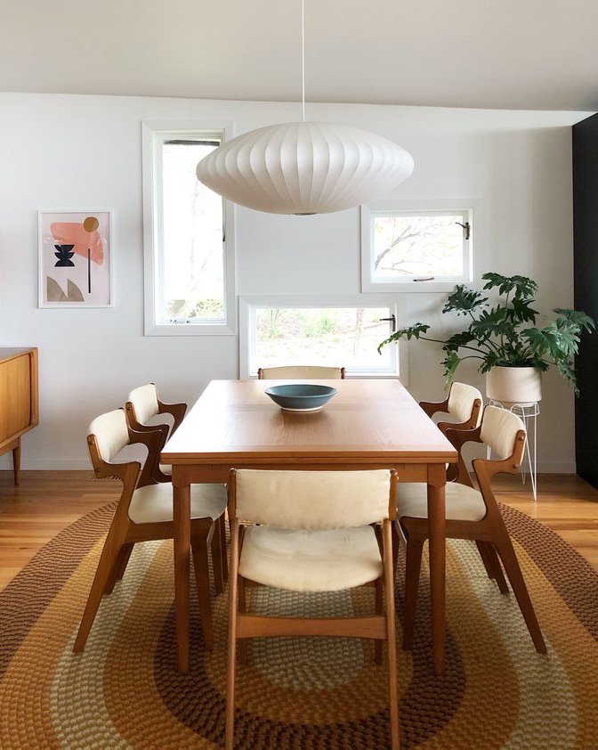 A mid-century modern dining room with Danish modern dining chairs and a white chandelier.