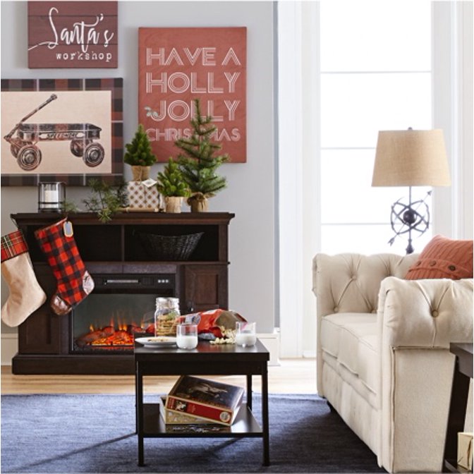 A traditional living room with a tufted sofa, stockings hung on the fireplace mantle, a roaring fire and bright light.