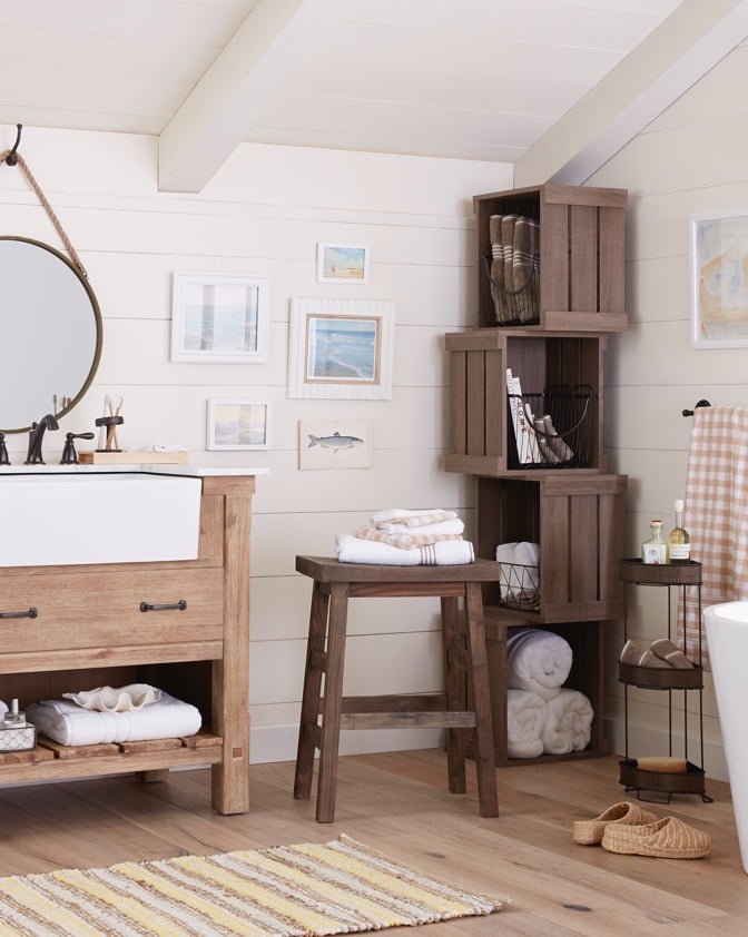 A farmhouse style bathroom with repurposed wood crates and a farmhouse sink.