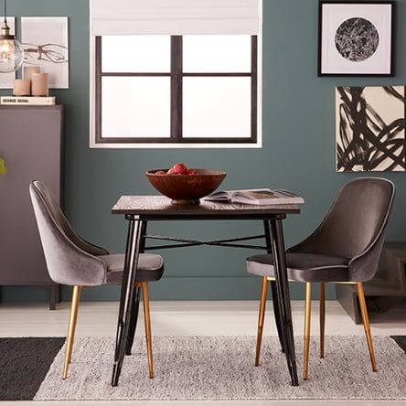 A modern dining room with velvet accent dining chairs and storage.