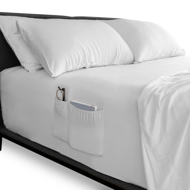 sábana de cajón queen size casa almaya mod blanco, vista 3/4 frontal de cama con sábana ajustable blanca y bolsillo lateral con gafas y teléfono, tela lisa de alta suavidad, 4 bandas elásticas para ajuste; adecuada para guardar accesorios pequeños junto a la cama.