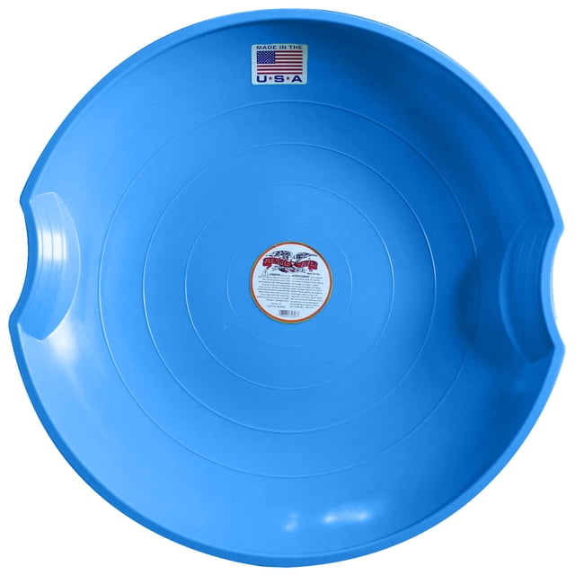 Flexible Flyer Flying Saucer 26-inch plastic snow sled in blue, designed for kids and adults. The round sled features a durable injection-molded polyethylene construction with molded hand grips for secure handling. Its 26-inch diameter provides a smooth ride for one person, making it ideal for snowy slopes. The sled is lightweight at 2 pounds and includes a bright blue finish with a central label and a 'Made in the USA' sticker.