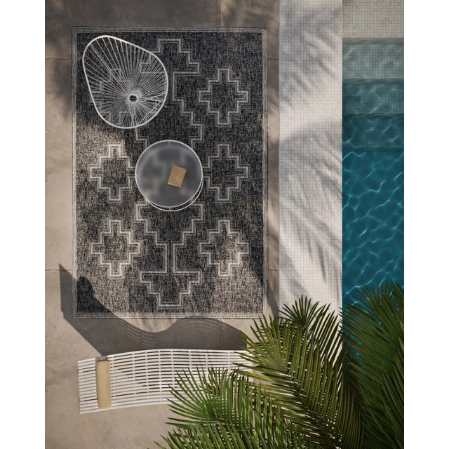 ECARPET Esina transitional area rug with black and gray geometric design displayed outdoors beside a swimming pool, styled with white wireframe chair and round table.