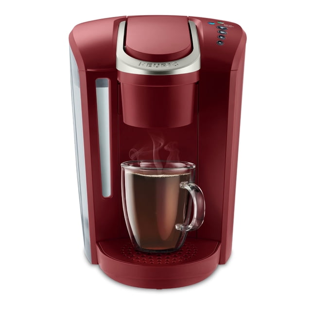 keurig k-select cafetera de cápsulas k-cup de una sola porción, rojo vintage con vista frontal 3/4; taza transparente con vapor en la bandeja. Silueta compacta con depósito de agua extraíble de 52 oz. a la izquierda, botones superiores para preparar 6–12 oz., función Strong Brew y tecnología Quiet Brew; apta también para té y chocolate caliente.