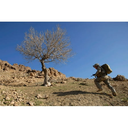 US Army soldier climbing a mountain ridge during a dismounted patrol in the Zabul province of Afghanistan Poster Print by Stocktrek