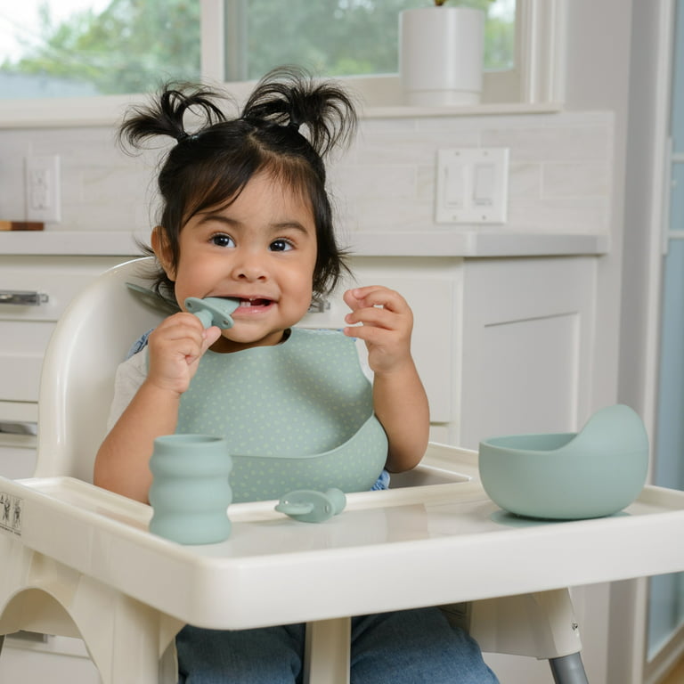 Premium Photo  A small child sits on a highchair and eats food from a  plate with a spoon. baby silicone utensils for feeding babies