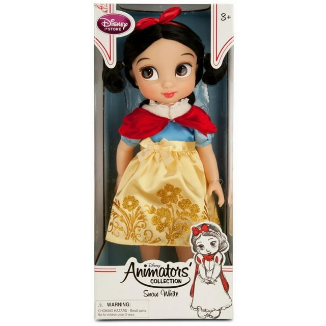 muñeca original de la colección de princesas Disney Animators, Blancanieves, 40 cm. Vista frontal en caja display: figura infantil con rostro estilo animado y ojos grandes; corpiño azul con mangas abullonadas, falda amarilla satinado con filigrana dorada, capa corta de velour roja con borde de piel sintética, diadema roja con lazo y calcetas con puntilla. Caja blanca con logo Animators y boceto de personaje, adecuada para colección y exhibición.