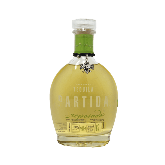 tequila partida reposado 750 ml Botella frontal de 750 ml Partida reposado con vidrio redondeado y cuello corto, tapa translúcida, líquido ámbar claro, marca PARTIDA en grande y texto reposado en cursiva verde, medallón metálico colgante en el cuello y sello de contenido 750 ml visible; a menudo se usa para preparar cocteles clásicos.