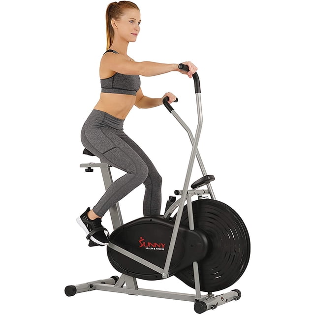 bicicleta de aire estática sunny health & fitness air hybrid sf-b2618 con ventilador con resistencia ilimitada y soporte para tablet 220lb gris, vista lateral frontal centrada de la bicicleta gris con rueda de ventilador grande y carcasa negra, estructura metálica gris, manubrios móviles tipo cruz, asiento acolchado ajustable arriba/abajo y adelante/atrás, pedales con correas y soporte para tablet; adecuada también para entrenamientos de resistencia en casa.