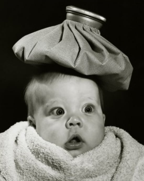 Closeup of a baby with an ice pack on his head Poster Print (18 x 24