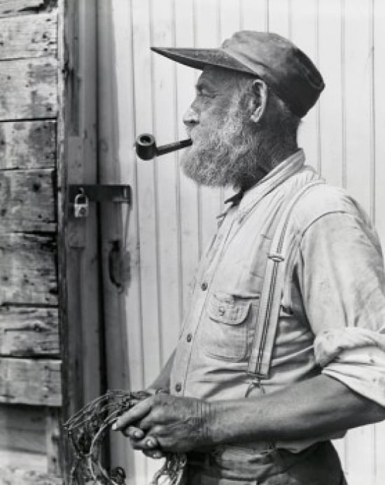 Side profile of a fisherman holding a fishing net and smoking a pipe Canvas Art - (18 x 24)
