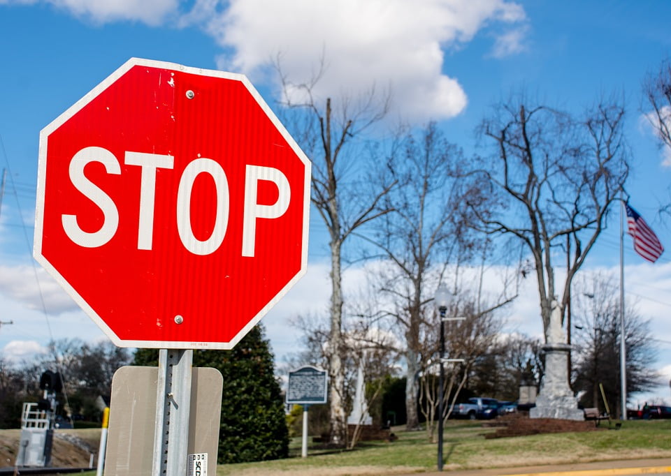 laminated poster winter stop sign trees town road blue sky red poster