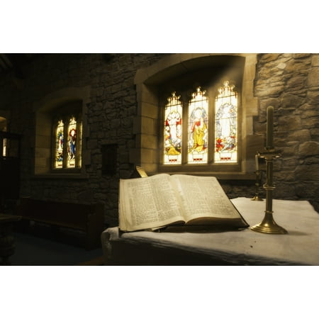 An open Bible on display in a church with colourful stained glass windows Bamburgh Northumberland England Stretched Canvas - John Short  Design Pics (38 x