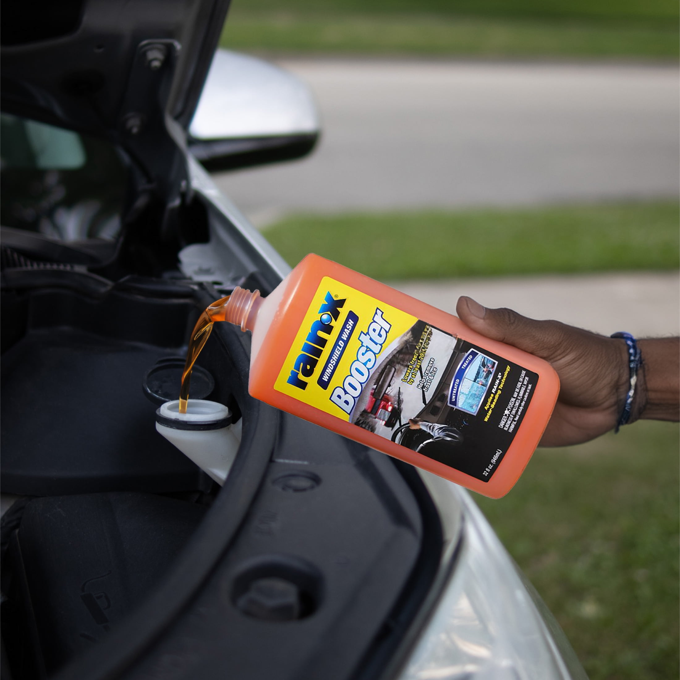 Rain-X washer fluid product being poured into a car washer reservoir