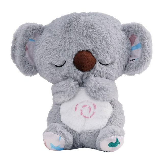 lindo koala que respira y brilla, oso que respira y que induce al sueño, muñeca de educación temprana con música koala de felpa gris de 27 cm, vista frontal centrada; vientre blanco con espiral bordada, nariz marrón y ojos cosidos cerrados, orejas y patas con estampado rosa y azul, textura peluche suave visible, simula respiración rítmica y reproduce 10 canciones de cuna hasta 30 minutos; funciona con 3 pilas AAA (no incluidas). Suele usarse también como cojín reconfortante en viajes cortos.