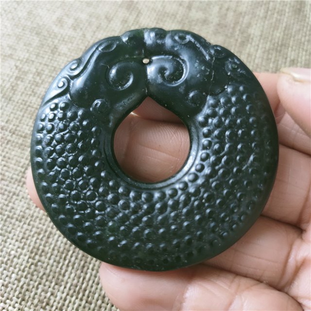 Jade pendant, made of black ink jade with openwork snake pattern, translucent green under light, magnetic jade.