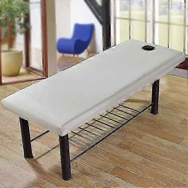massage bed sheet, massage spa couch forepart hole polyester elastic all-round wrap soft comfortable massage elastic edge solid couch elastic edge sol blanco; funda para camilla de masaje ajustable 70×190 cm (27.56×74.80 in) con orificio facial delantero y borde elástico de cordón que evita deslizamientos, tejido poliéster de textura suave visible, apta para camillas hasta 80 cm; imagen en salón con piso de madera y silla azul al fondo; paquete incluye 2 piezas, a menudo usada por terapeutas y salones.