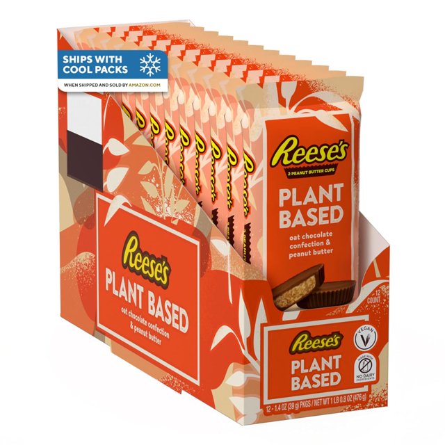 plant based oat chocolate confection peanut butter cups, candy packs, 1.4 oz (12 count) caja de 12 paquetes individuales en presentación desplegable con diseño naranja, vista en 3/4 que muestra paquetes alineados y un cup abierto que revela relleno cremoso de mantequilla de maní y cubierta de chocolate de avena; certificados vegano y kosher visibles; ideal como postre o aperitivo para viajes y meriendas.