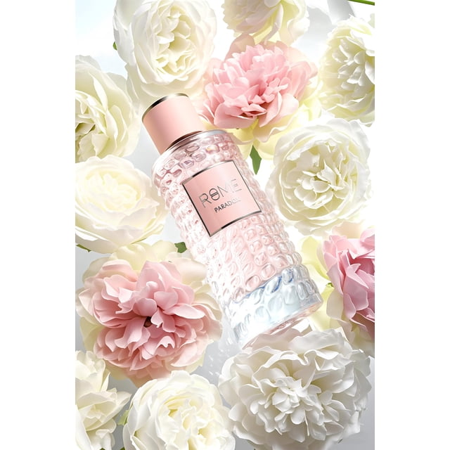 bharara rome paradox 100ml edp spray eau de parfum botella multicolor 100 ml con líquido rosa pálido, vista diagonal centrada que muestra cuerpo de vidrio texturizado con patrón de burbujas y etiqueta 'ROME PARADOX'; tapa rosa mate; fondo de flores blancas y rosa pálido que sugiere notas florales y afrutadas.