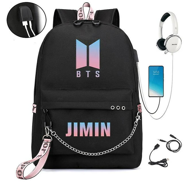 mochila bts del mismo estilo para hombres y mujeres con puerto de carga USB; vista frontal centrada de mochila escolar negra con logotipo BTS degradado rosa-azul en el panel superior y texto JIMIN en la solapa frontal, bolsillo con cremallera, correa lateral rosa impresa y cadena plateada, asas acolchadas y puerto USB externo visible; a menudo usada por estudiantes para llevar libros y cargar dispositivos.