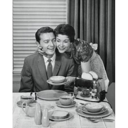 24' Bowl Shade Young woman holding a bowl and embracing a young man sitting at the dining table Stretched Canvas - (18 x 24) ()