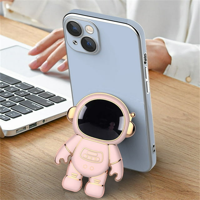6d plating astronaut hidden stand para iphone 13 pro max soporte para teléfono brillante para huawei para samsung Soporte oculto de astronauta enchapado 6D rosado, vista 3/4 frontal de figura astronauta pegada a la trasera de un teléfono, casco reflectante negro con borde dorado, cuerpo rosa con detalles dorados y extremidades articuladas; tamaño 7x4 cm (2.76x1.57 in), TPU, colocado verticalmente sobre mesa de madera para sostener un iPhone 13 Pro Max; compatible con iPhone, Samsung y Huawei. Ideal también como soporte decorativo para ver videos.