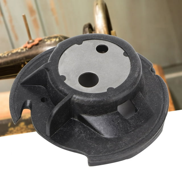 Bobbin Case, Multifunctional Durable Plastic Household Replacement Bobbin Case for Brother Sewing Machine shown in a close-up view. The black plastic case features a circular design with precise cutouts, durable and anti-corrosion material, and a smooth finish. Suitable for various Brother sewing machine models including CS-6000i and SE-400, it ensures efficient thread cutting and prevents tangling. Positioned against a blurred sewing machine background.