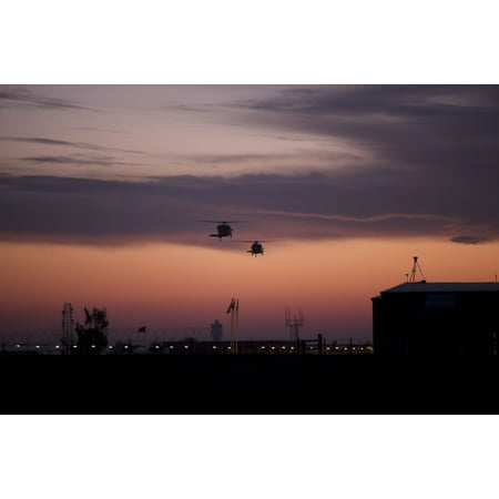 - A pair of UH-60 Black Hawk helicopters approach their landing during sunset at Victory Pad Baghdad Iraq Poster Print