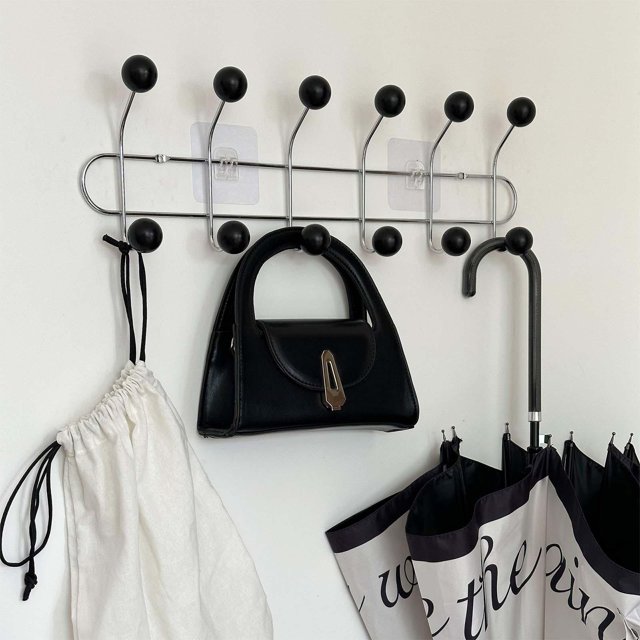 perchero de pared, gancho de pared, perchero, gancho para abrigos, colgador de pared de metal para colgar abrigos, mochilas, chaquetas, vestíbulos, 6 ganchos Perchero montado en pared blanca, vista frontal de la barra metálica cromada de 49.5 cm con seis ganchos rematados en bolas de madera negras, fijada con dos soportes adhesivos; colgado con un bolso negro, una bolsa blanca y dos paraguas, adecuada también para toallas o mochilas pequeñas.
