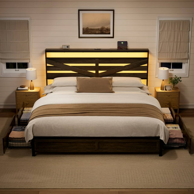 GUNAITO King Bed Frame with Storage Headboard & 4 Drawers, shown in a dark gray industrial metal design with a built-in charging station and RGB LED lighting. The headboard features a warm backlit design with adjustable brightness, while the bed frame includes four under-bed storage drawers with pulleys for easy access. The sturdy steel and wood construction ensures durability and noise-free use. The bed is styled in a cozy bedroom setting with neutral decor, bedside tables, and soft lighting.