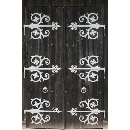 Large Metal Decorative Hinges On A Weathered Wooden Barn Door