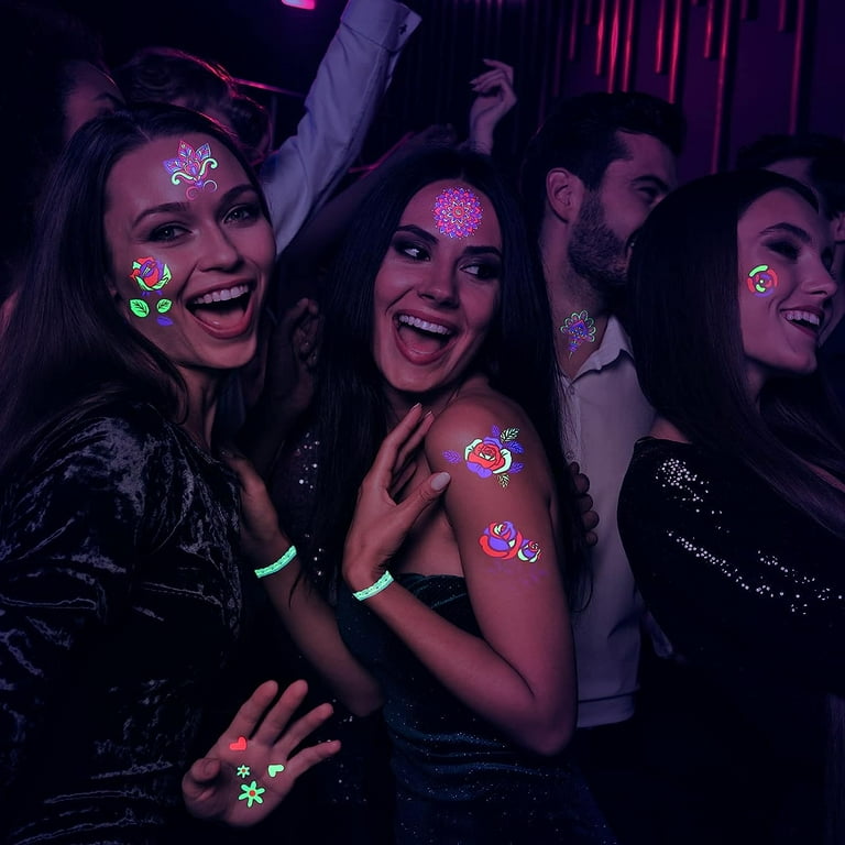 A person showing their UV tattoo under blacklight at a nightclub, highlighting the popularity of glow-in-the-dark tattoos in nightlife culture.