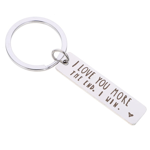 Llavero de acero inoxidable con texto "Te amo más", ideal para colgar en bolsas.