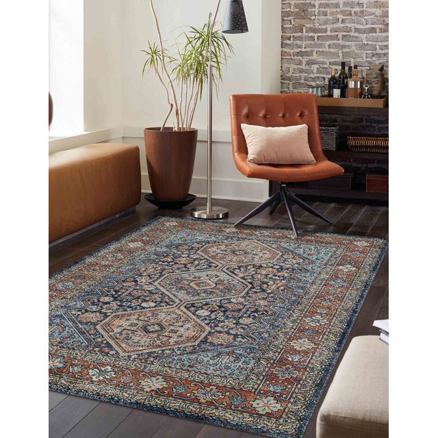ECARPET Alicia traditional area rug featuring detailed geometric and floral designs in blue, beige, and rust tones on dark hardwood flooring with contemporary furniture around.