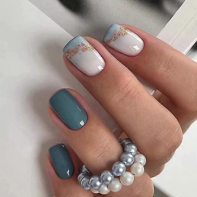 uñas postizas cortas cuadradas de presión, color azul claro degradado con purpurina dorada, color nude, reutilizables — mano en vista 3/4 con uñas cortas de forma cuadrada: base nude con degradado azul claro y finas partículas de purpurina dorada en la transición; dos uñas muestran azul sólido; acabado brillante, prepegadas para aplicación rápida y aptas para uso diario.