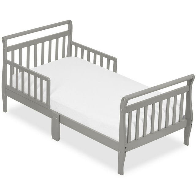 Gray Dream On Me Sleigh Toddler Bed with protective side rails and white mattress.
