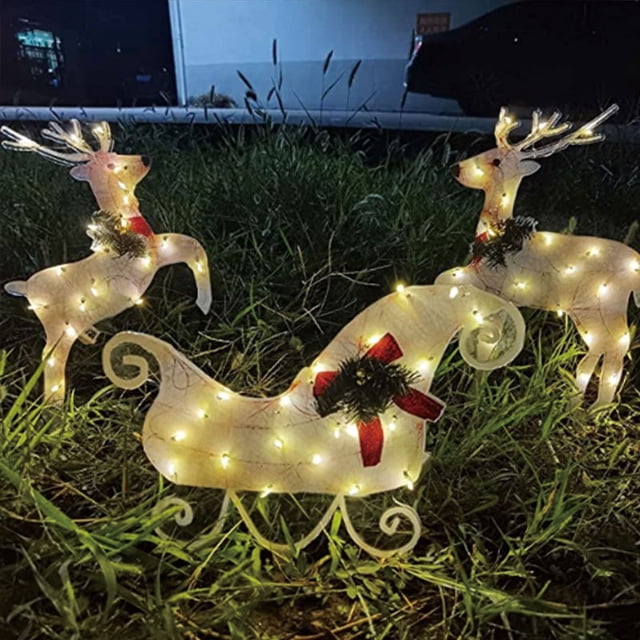 Las decoraciones navideñas con luces LED iluminan el patio con muñecos de nieve, trineos, alces y pingüinos.