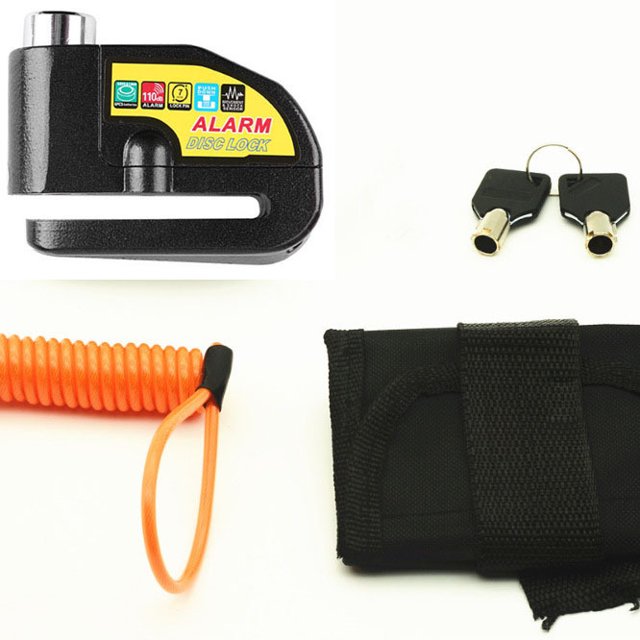 candado de disco de alarma antirrobo para motocicleta candado de disco de scooter con alarma de 110db, 2 llaves, cable antirrobo de 1,2 m, 1 bolsa de candado de disco de alarma para motocicleta/bic — Candado de disco negro con etiqueta amarilla "ALARM DISC LOCK", pasador metálico, dos llaves negras con casquillo metálico, cable enrollado naranja de 1,2 m y funda negra de tela con velcro; apto para moto, scooter y bicicleta y a menudo usado como cable puente para estacionado temporal.