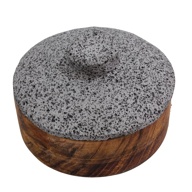 tortillero de madera parota con tapa de piedra volcánica, cemcui, 21 cm de diametro — Vista frontal elevada de tortillero redondo; base de madera parota con vetas visibles y tapa de piedra volcánica gris porosa con perilla central; medidas: 21 cm diámetro exterior, 18.5 cm diámetro interior, profundidad interior 5 cm; apto para servir y conservar tortillas o como recipiente decorativo en cocina.
