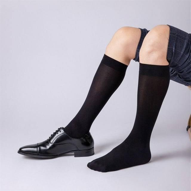 Lefu Chaussettes Habillées Transparentes pour Hommes, Bas Transparents Ultra Minces Extensibles en Noir, Montrées Portées sur les Jambes avec un Pied dans une Chaussure Habillée Noire et l'Autre Pied Nu. les Chaussettes Sont de Longueur Moyenne, Faites de nylon, et Présentent un design Transparent et Extensible Convenant aux Tenues Formelles Ou de Bureau. Convient aux Tailles EUR 36-46, US 4.5-12, et UK/AU 4-11.5.