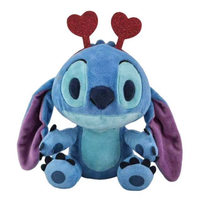 peluche de san valentín disney stitch con diadema de corazón 20 cm Peluche Stitch azul de 20 cm, vista frontal sentado con cara bordada y diadema de dos corazones rojos brillantes; felpa suave, orejas largas con interior lila y patas con almohadillas visibles sobre fondo blanco. A menudo usado como figura de colección o regalo temático.
