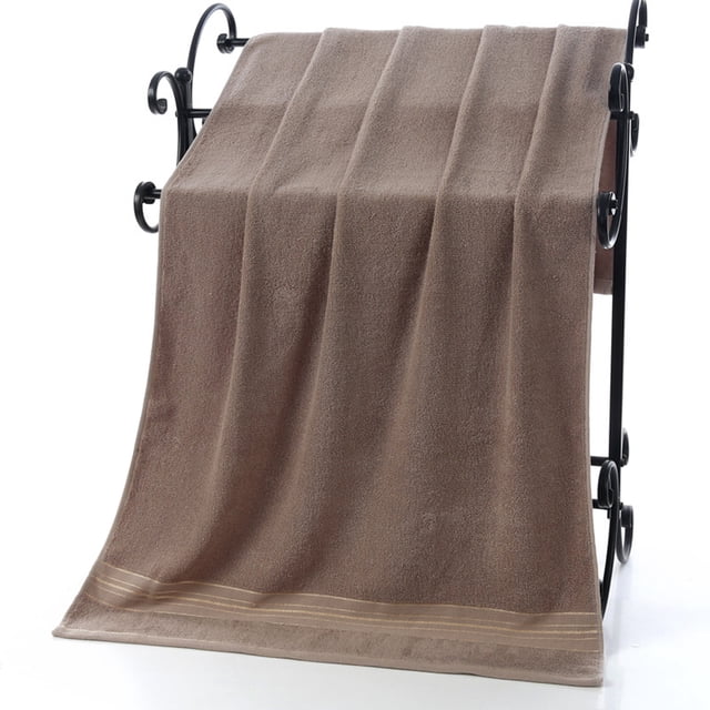 toalla de baño (70 cm x 140 cm) de algodón extragrande color café, vista frontal centrada sobre un tendedero, silueta rectangular con dobladillo y franjas en el borde inferior, tejido de coral polar con rizo visible y textura absorbente, tamaño aprox. 140 x 70 cm, uso múltiple para baño, spa, viajes y deportes; también adecuada para secar cabello o como toalla de viaje.