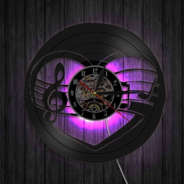 reloj de pared con grabación de vinilo musical reloj de pared con luz led y notas musicales reloj de vinilo decoración de pared para sala de estar regalos únicos para amantes d. Vista frontal centrada de un disco de vinilo negro de 30 cm troquelado con clave de sol y pentagrama; esfera mecánica negra con números arábigos y manecillas doradas en el centro. Luz LED trasera (púrpura en la foto) con cable de alimentación visible; ideal también para decorar estudios musicales o espacios de entretenimiento.