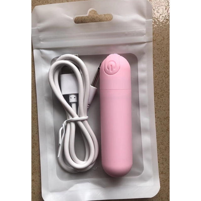 mini vibrador de bala recargable por usb de 10 frecuencias rosa, vista frontal centrada de cuerpo cilíndrico con cabeza redonda y botón de encendido; incluye cable USB blanco enrollado en empaque transparente sobre bolsa blanca. A menudo se usa como masajeador puntual compacto para viajes.