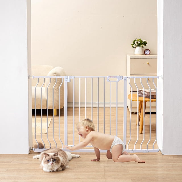 puerta de seguridad vevor 29.5-51 extra ancha para escaleras y puertas blanca, vista frontal a nivel medio de una puerta metálica de barrotes verticales con liberación de doble bloqueo en la parte superior y cierre automático; montaje a presión entre jambas, 30 in de alto y ajuste 29.5–51 in de ancho; niño gateando y gato frente a la puerta; doble vaivén 180° que se mantiene abierto a 90°. También suele usarse como barrera temporal para áreas de juego pequeñas.