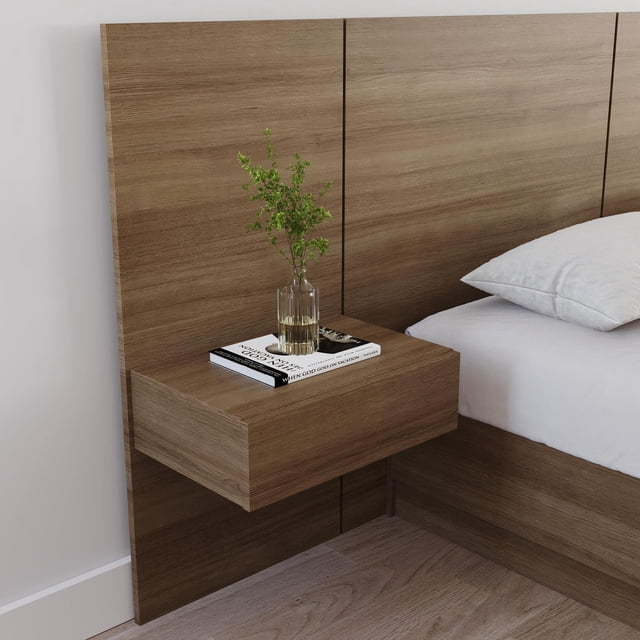 Nexera Milano floating nightstand extension panel in wood finish mounted on matching wooden headboard next to bed, holding a glass vase with greenery and a book.