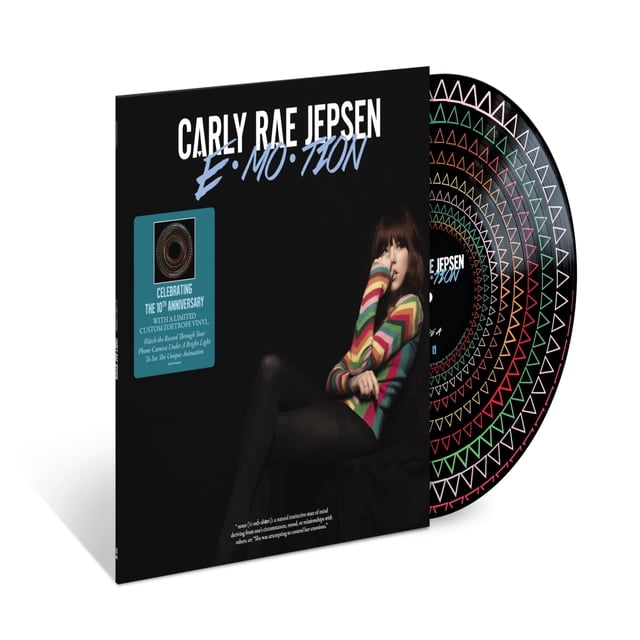 Carly Rae Jepsen - EMOTION (10TH ANNIVERSARY EDITION ZOETROPE) vinyl record set featuring a black album cover with the title in bold white and blue text. The cover includes a seated figure wearing a colorful striped sweater. The limited-edition zoetrope vinyl is partially visible, showcasing a vibrant geometric pattern in red, green, and white. A sticker on the cover highlights the remastered audio and unique animation feature viewable under a bright light.